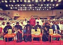 Prelates seated before a large audience